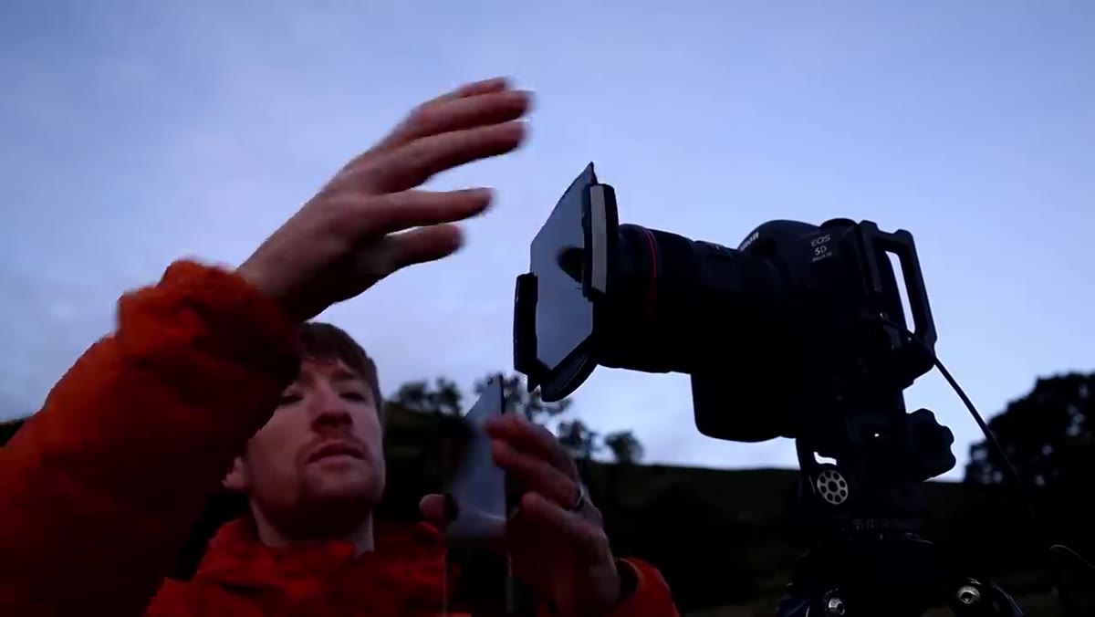 Heaton attaching ND filter to lens, adjusting camera settings