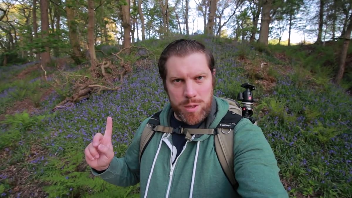 Photographer arriving at bluebell woodland at dawn