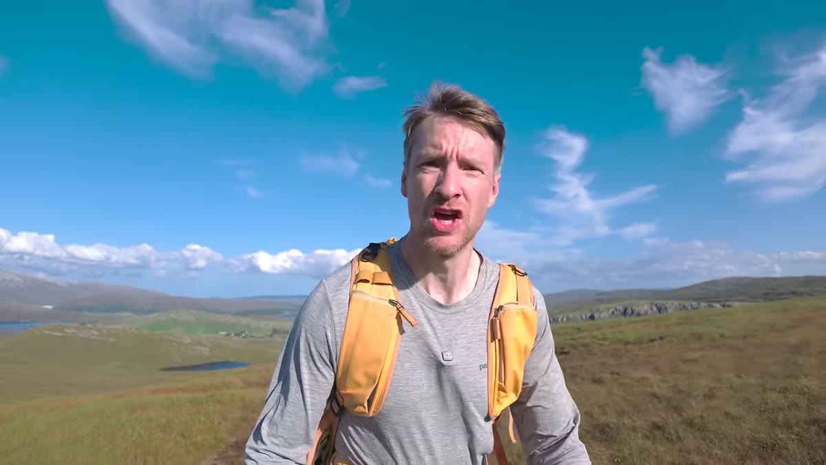 Heaton pausing on the trail with steeper terrain visible ahead