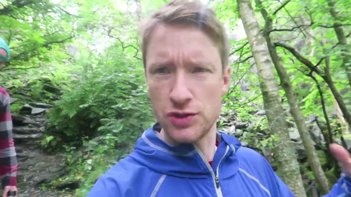 Thomas walking through overcast woodland, camera not yet out