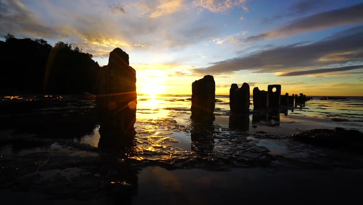 Photographer moving along pillar edge, sunstar appearing in frame