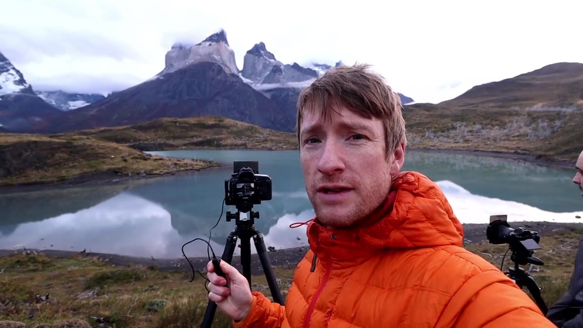 Camera on tripod, long exposure being taken of misty mountains