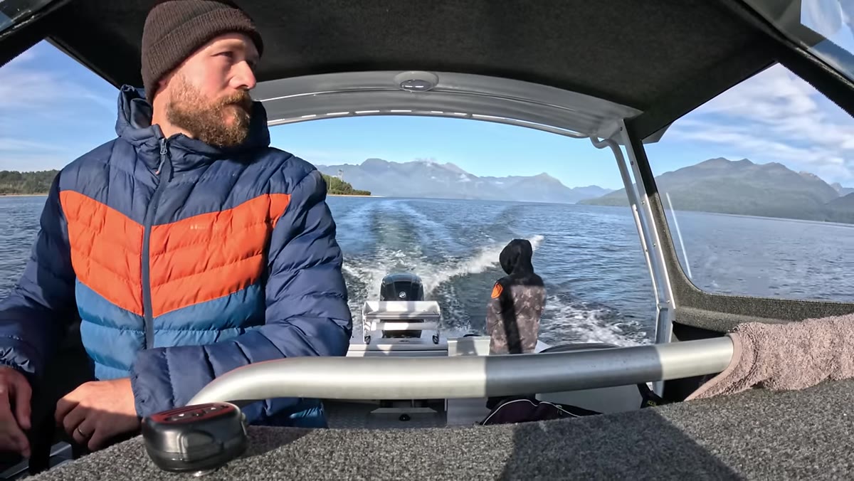 Boat on lake with mountain range visible in background