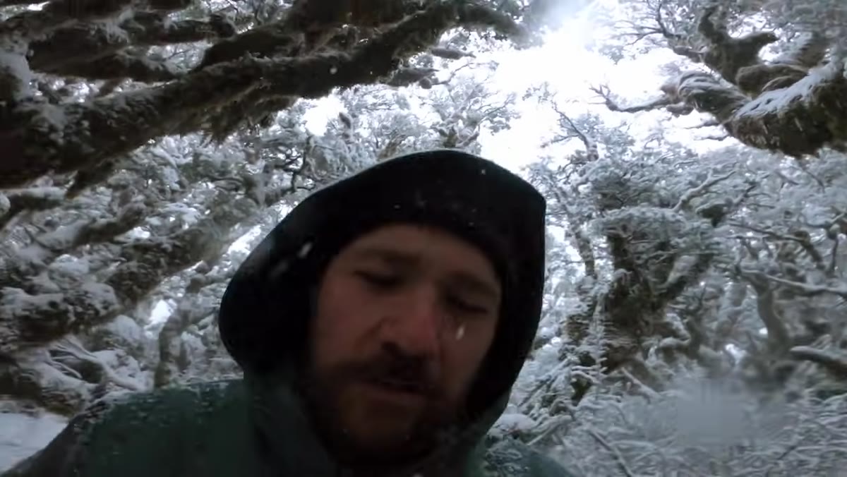 Patino turning away from wind to shield lens during snowfall