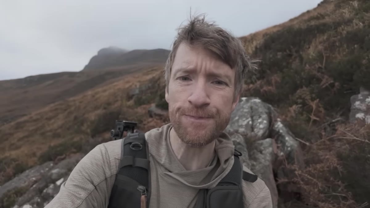 Heaton turning to show islands opening up behind him on the trail