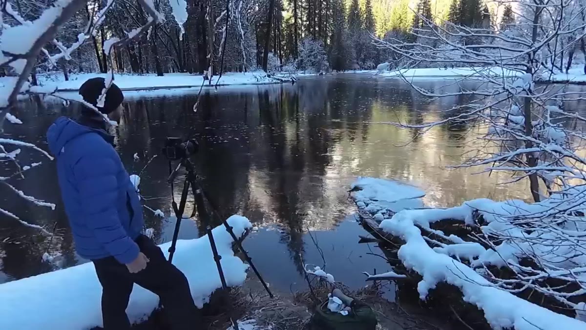 Camera on tripod with circular polarizer attached, stream in foreground
