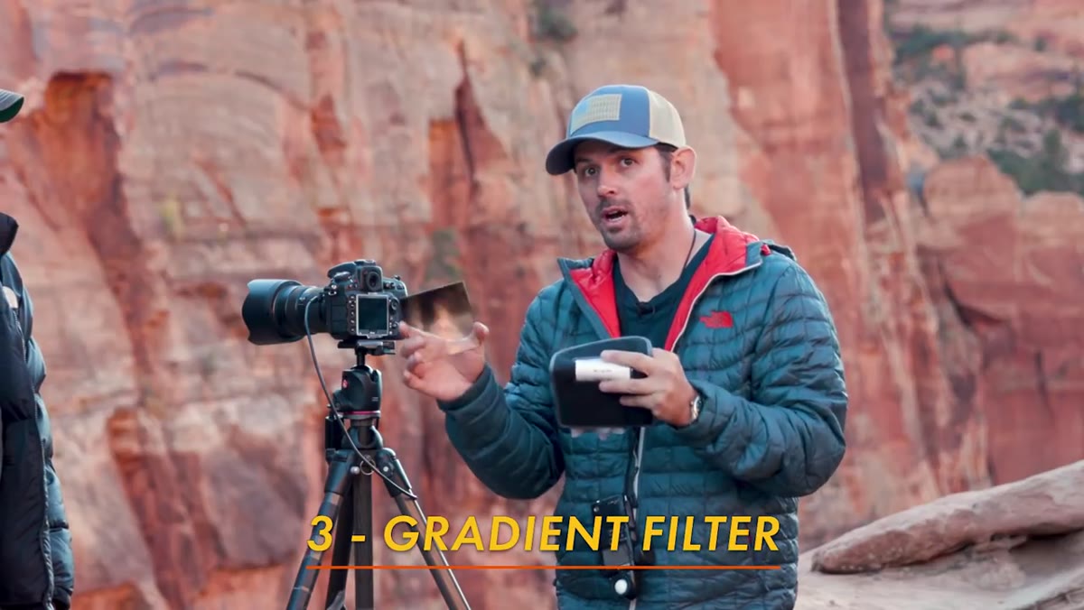 Shane holding graduated ND filter up in front of lens outdoors