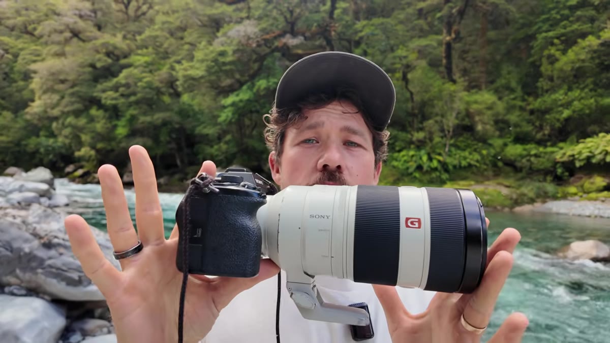 Camera with 100-400mm telephoto lens visible on screen