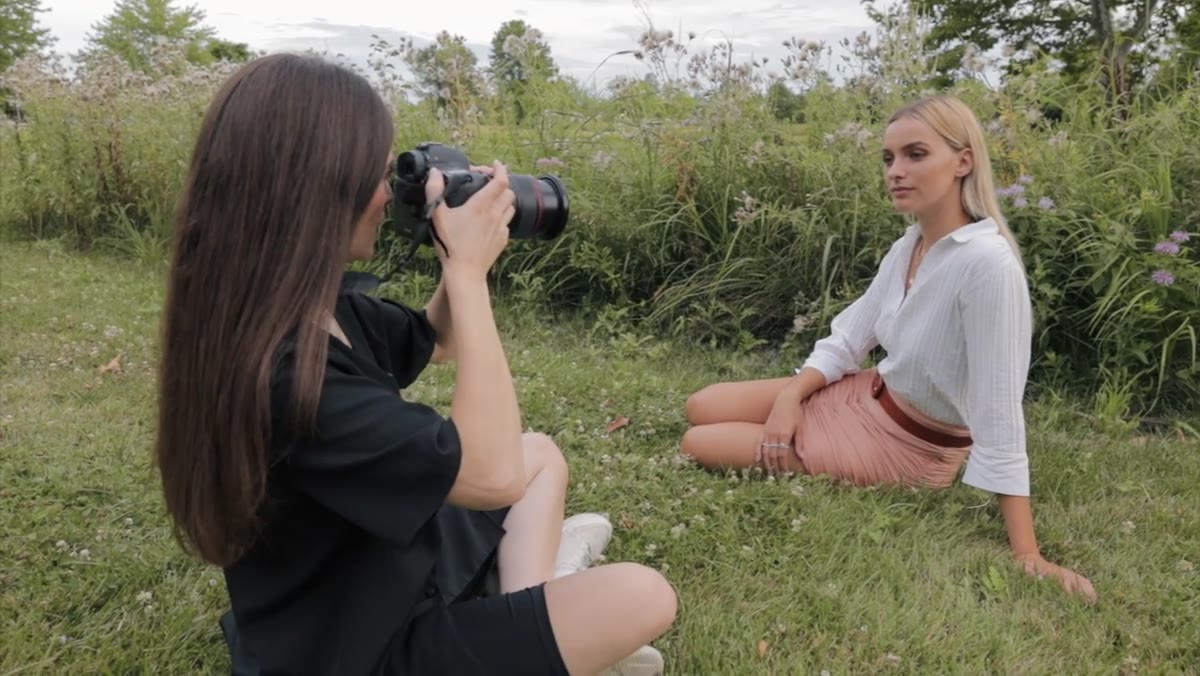 Photographer crouching to match seated subject&rsquo;s eye level
