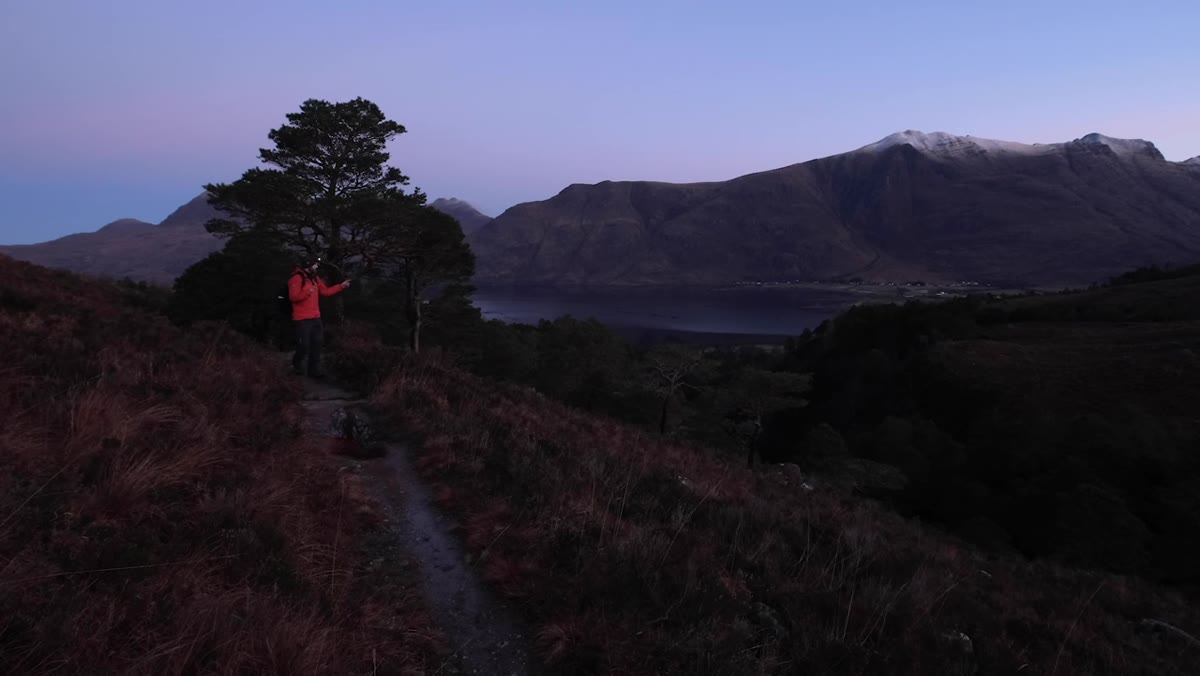 Nigel pointing out Scots pines and the river valley with mountains behind