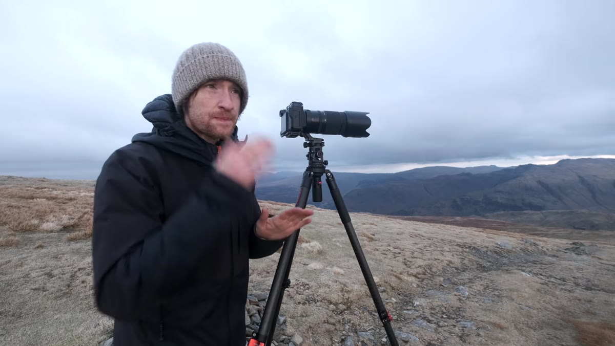 Long lens framing a lit saddle with cloud layers and depth