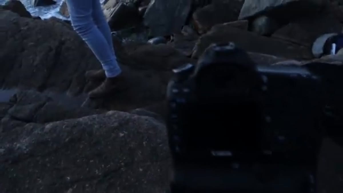 Photographer showing series of seascape images captured from low angle near water
