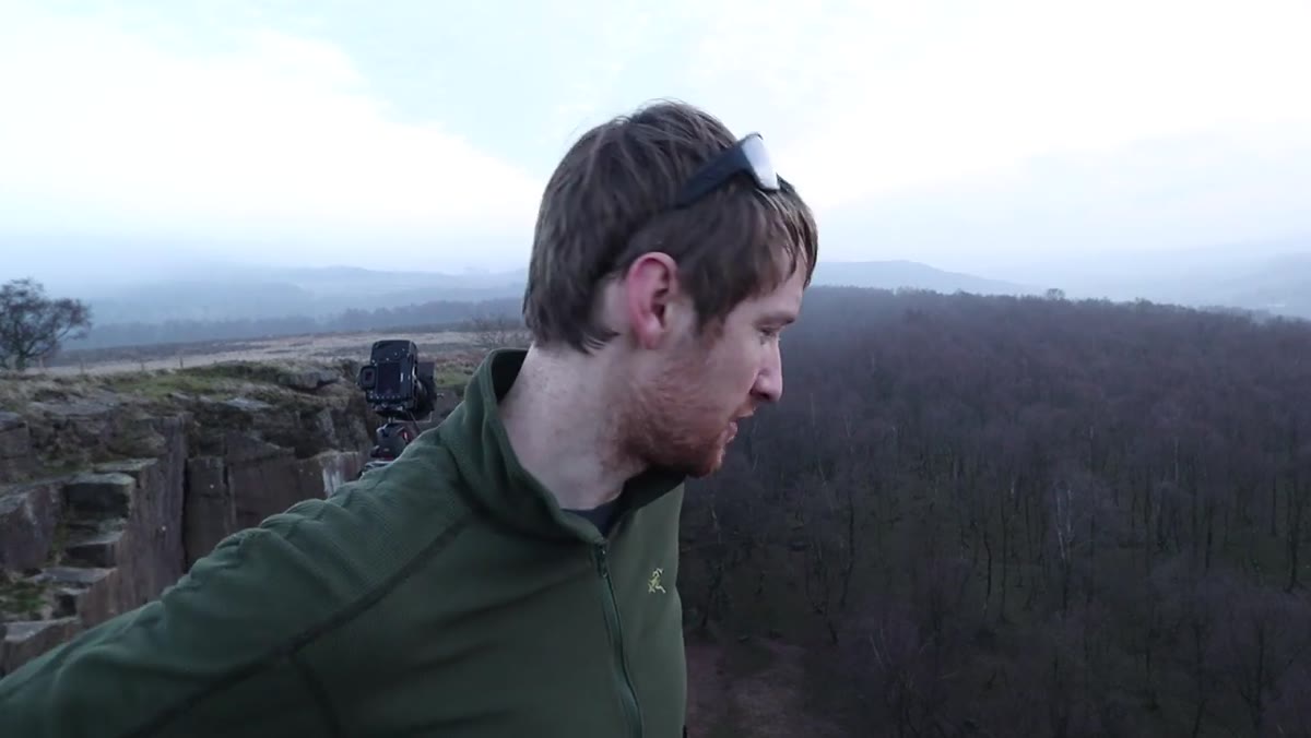 Heaton perched on precarious ledge with camera, describing his footing