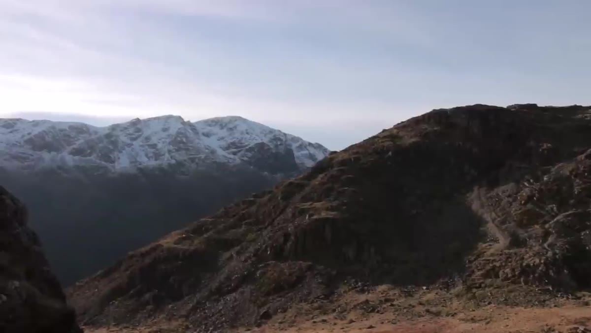 Mountain slope running diagonally across the frame toward snow-capped peak