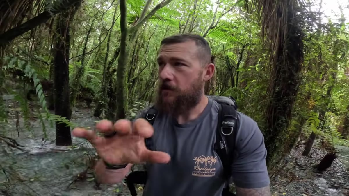 Patino assessing a new rain-formed stream winding through trees