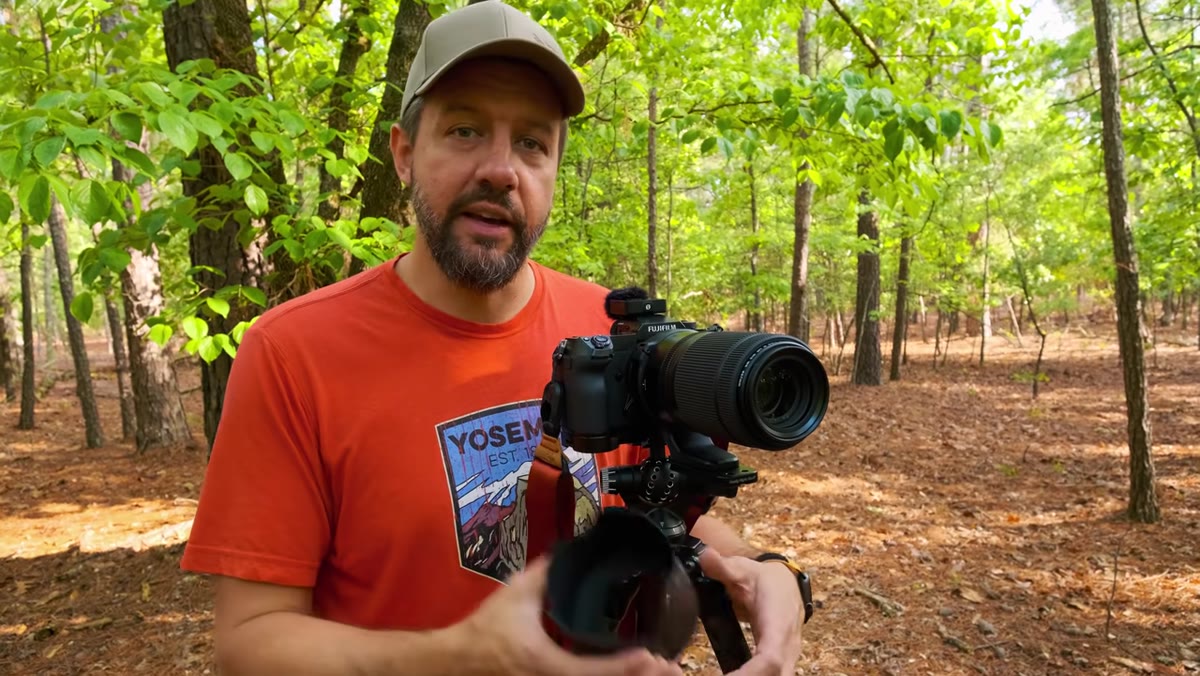 Telephoto lens with lens hood mounted on tripod ball head