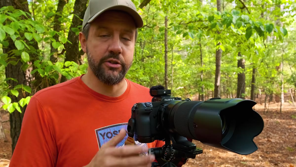 Photographer standing beside camera blocking wind direction